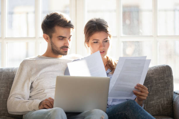 Pareja joven revisando documentos de alquiler tras recibir requerimiento de pago